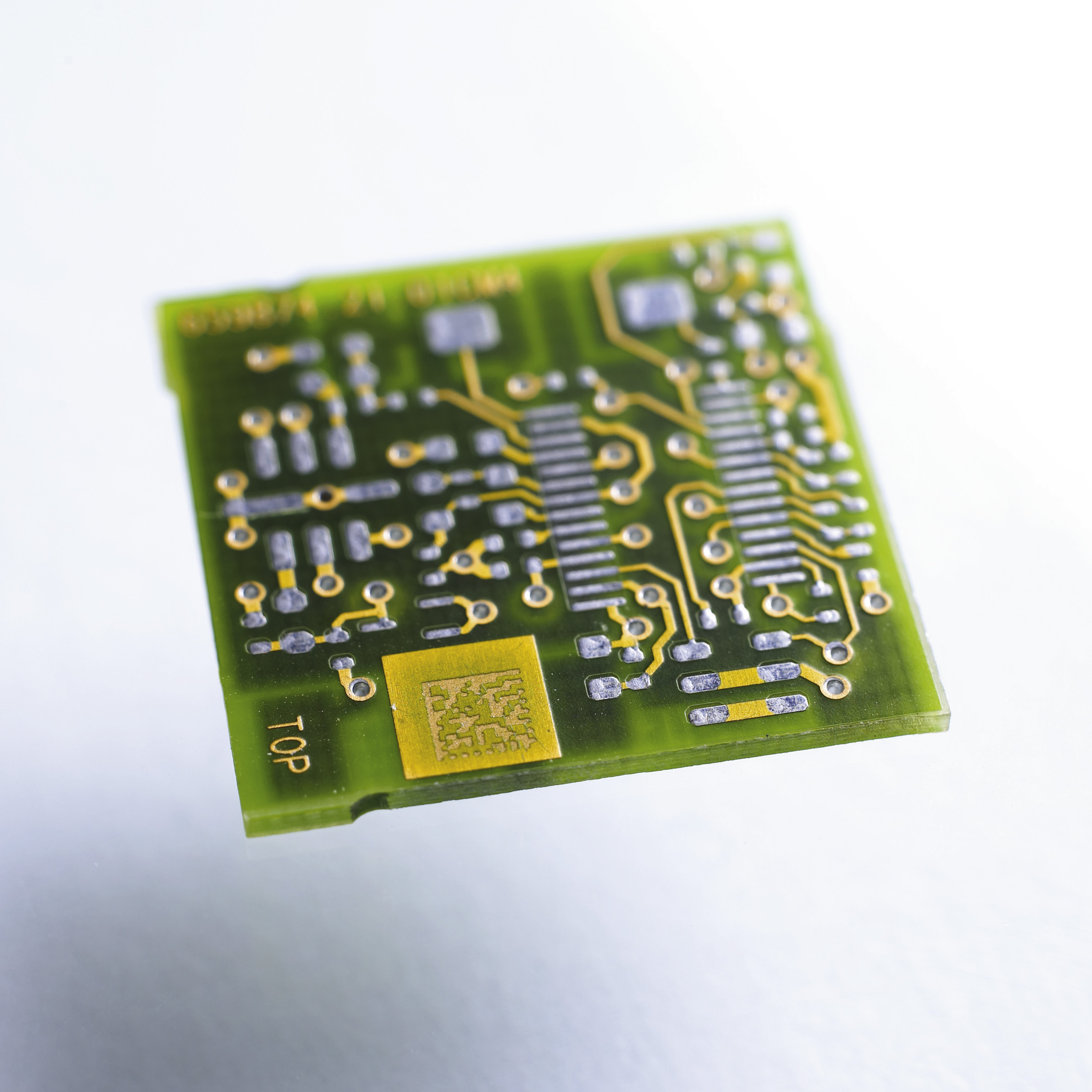Laser marked PCB circuit board with intricate 2D Matrix code and electronic components, showcasing Evright Industrial's advanced marking technology for electrical applications.